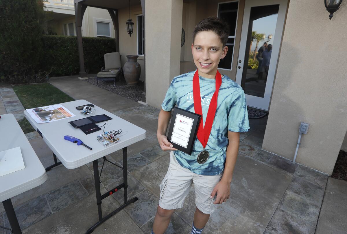 Ryan Honary, 12, shows off his American Red Cross Disaster Services Award at his Newport Coast home.