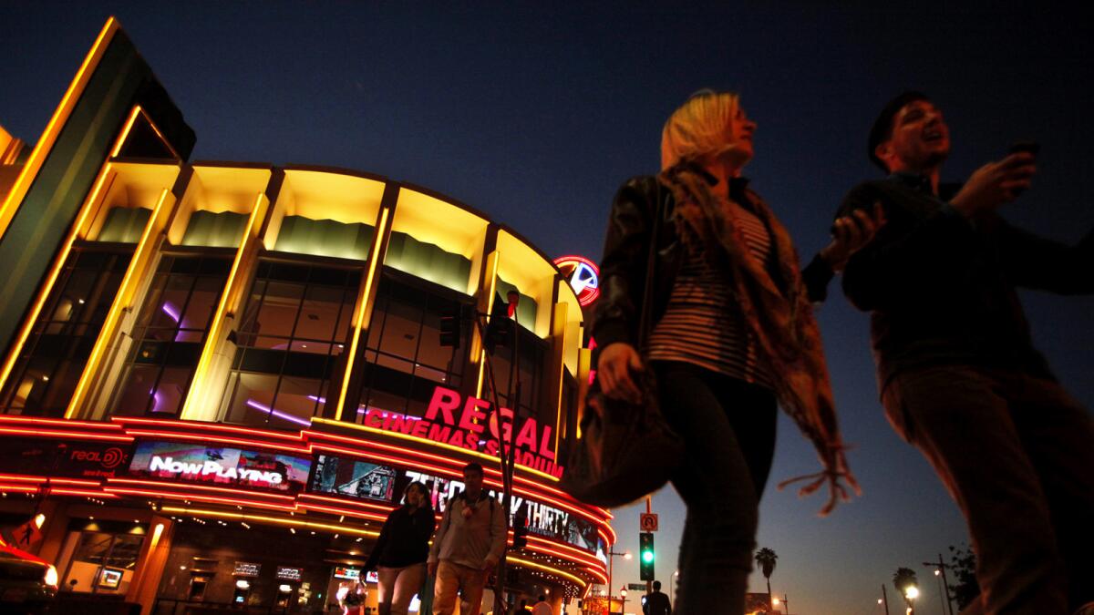 People stroll past the Regal Cinemas LA Live Stadium 14 in Los Angeles.