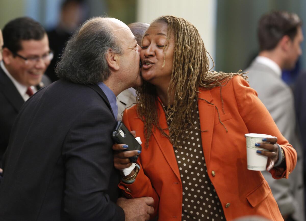 Assemblyman Katcho Achadjian (R-San Luis Obispo), left, greets Assemblywoman Holly Mitchell (D-Los Angeles) as lawmakers gather after the Labor Day holiday at the Capitol earlier this month. Mitchell has won a special election for the state Senate seat vacated by Democrat Curren Price.