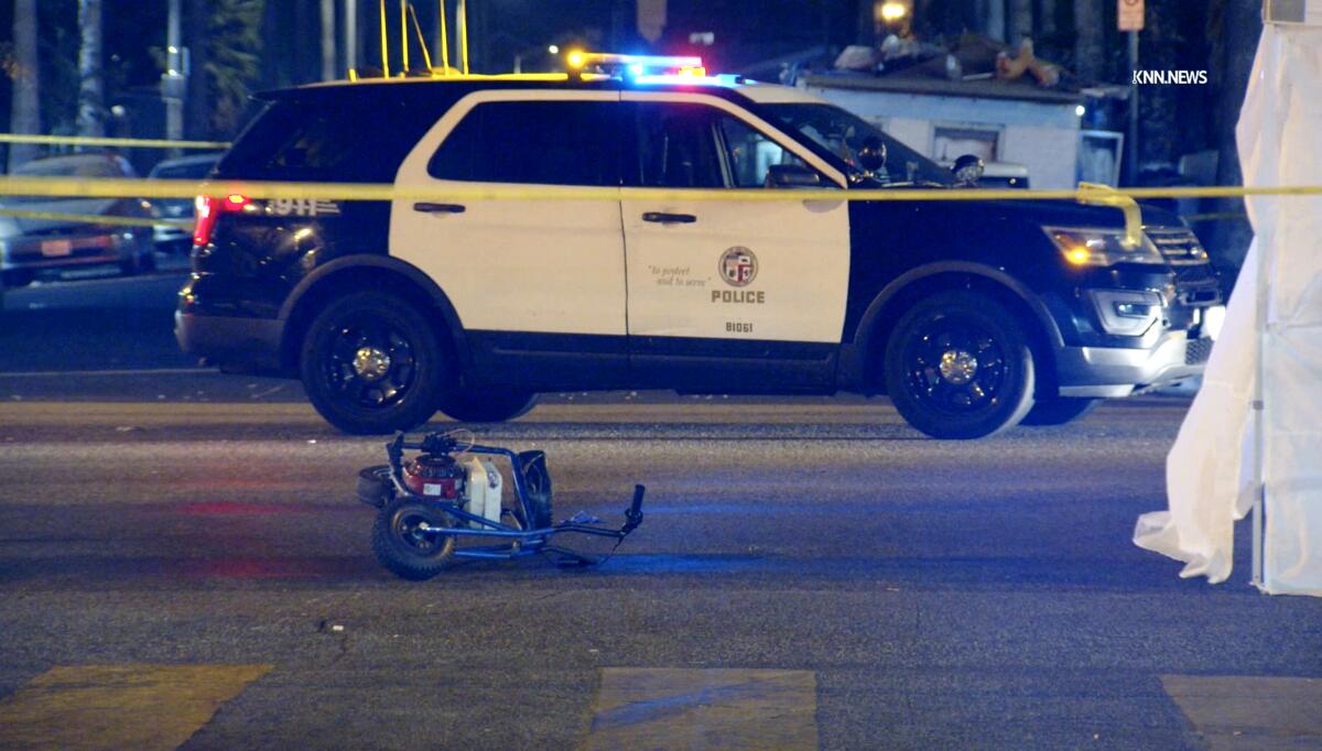 Una pequeña bicicleta se sienta cerca de un vehículo policial en una carretera.