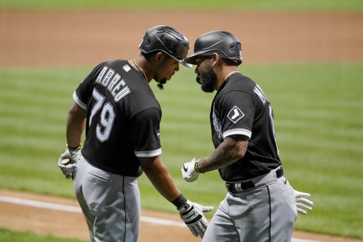Chicago White Sox's Yoan Moncada is congratulated by Jose Abreu (79) after hitting a home run during the ninth inning of a baseball game against the Milwaukee Brewers Monday, Aug. 3, 2020, in Milwaukee. (AP Photo/Morry Gash)