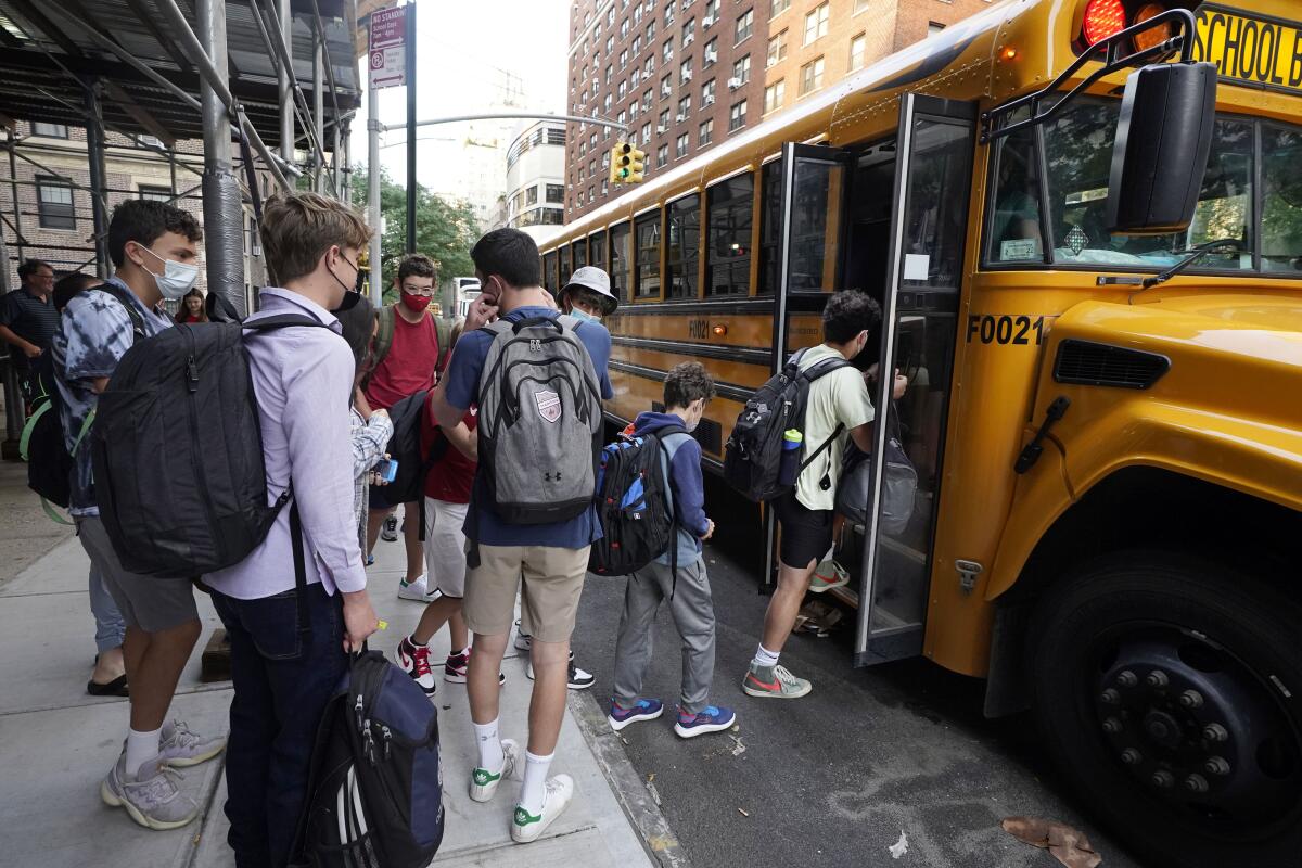 Students board a school bus