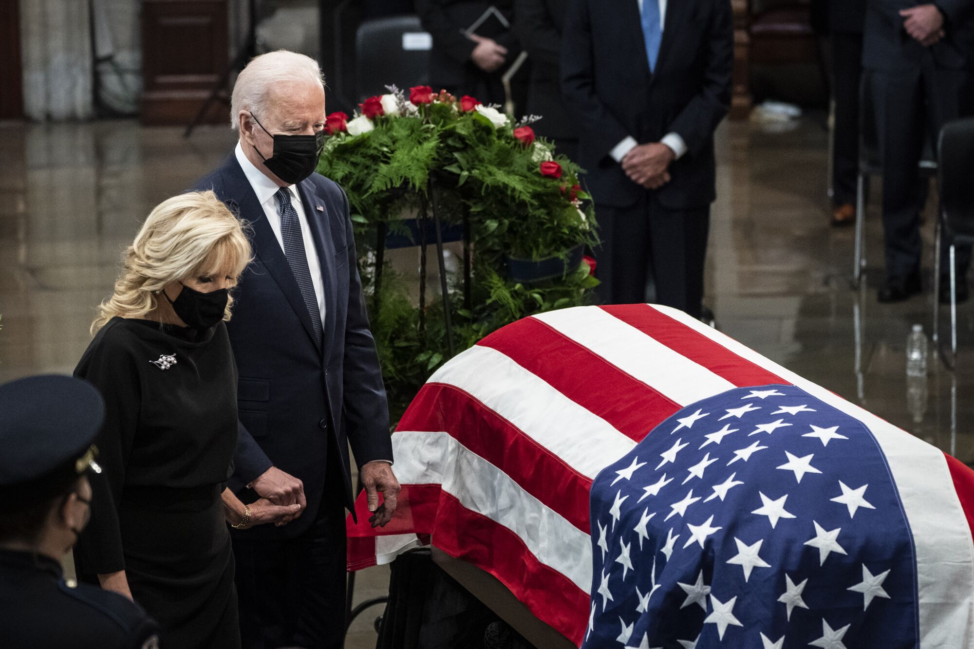 President Biden and First Lady Jill Biden stand next to the U.S. flag-draped coffin of Bob Dole.