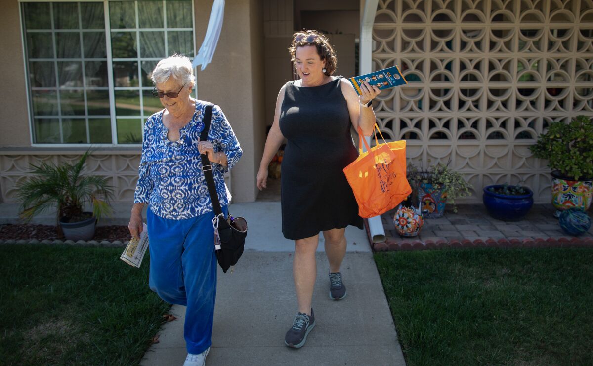 Temsilci Katie Porter (D-Irvine), sağda, bir kampanya durağı sırasında bazı evleri geziyor.