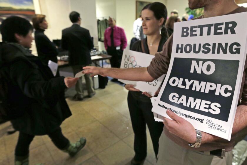 Jonathan Cohn, right, and Claire Blechman hand out fliers in Boston opposing the city's bid to host the 2024 Summer Olympic Games.