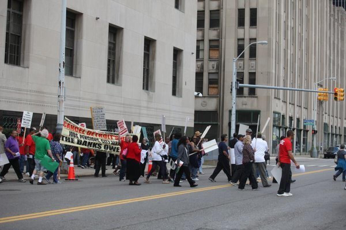 Protesters cross the street in front of federal court in Detroit on Aug. 2.