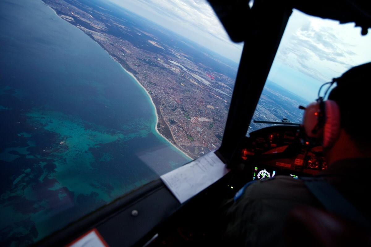 A crew onboard an RAAF AP-3C Orion crossing the coast of Perth, Australia, having just completed an 11-hour search mission for missing Malaysia Airlines Flight 370, before landing at RAAF Pearce airbase in Perth on Monday.