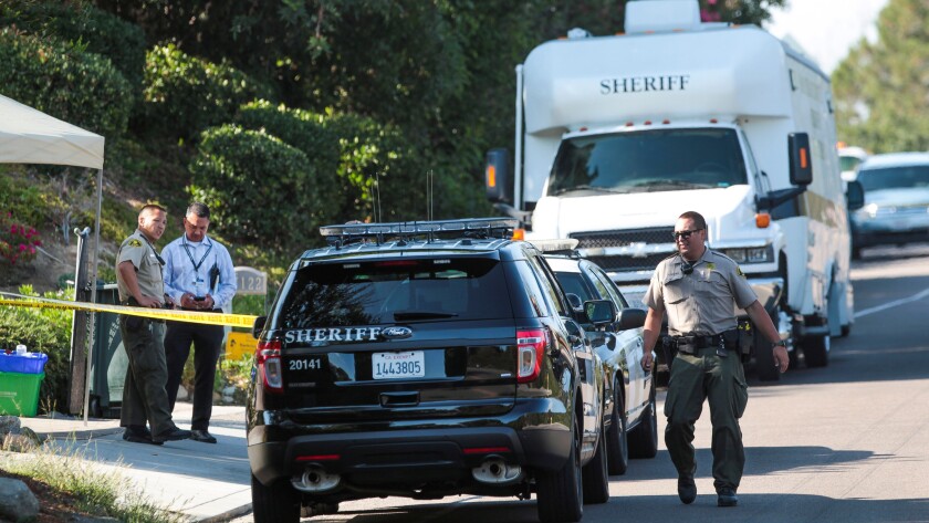 Sheriff s deputies investigate at the Rancho Santa Fe home where three people were found dead on Monday.