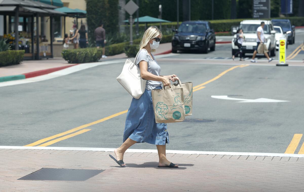 A shopper leaves Whole Foods in Fashion Island on first day of the latest shutdown of business.