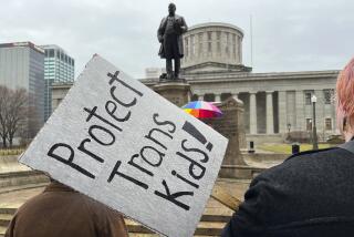 FILE - Demonstrators advocating for transgender rights and healthcare stand outside.