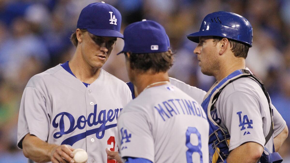 Dodgers pitcher Zack Greinke, left, hands off the ball to Manager Don Mattingly, center, as he leaves the game, as catcher A.J. Ellis looks on in the sixth inning of the Dodgers' 5-3 loss to the Kansas City Royals on Monday.