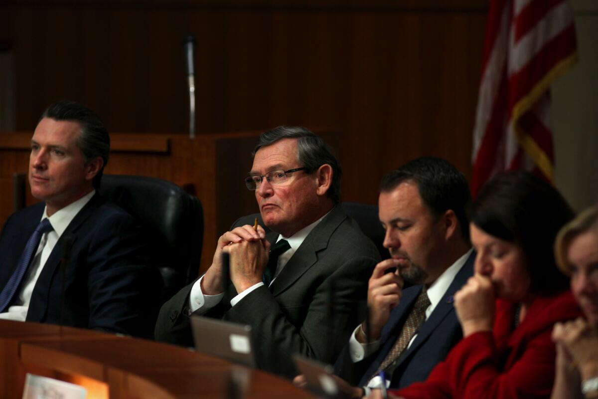 Left to right, Lt. Gov. Gavin Newsom; CSU Chancellor Timothy P. White; Chair Lou Monville; and Speaker of Assembly Toni G. Atkins listen to public speakers Tuesday morning at the California State University Board of Trustees Meeting held at Dumke Auditorium in Long Beach.