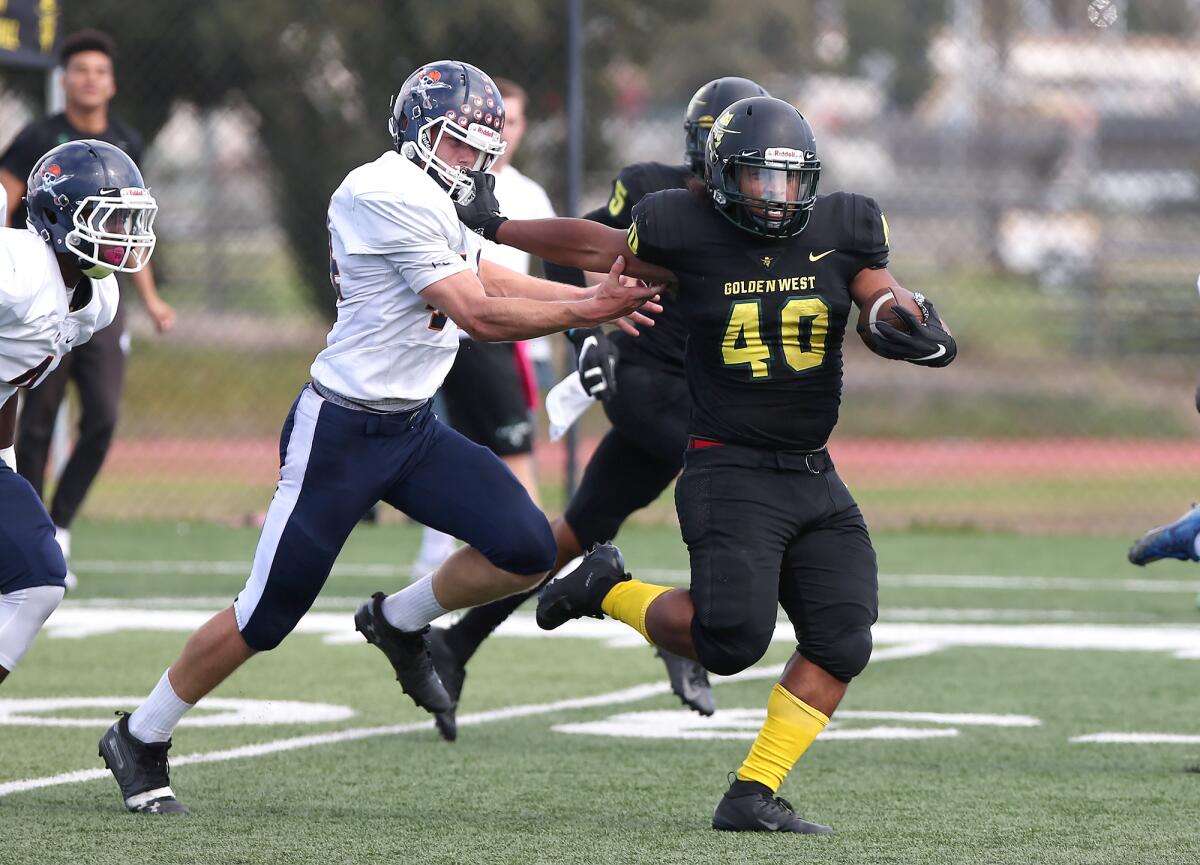 Golden West College running back Devon Jackson (40) tries to elude Orange Coast College's Zeke Alleman, who gives chase during a National Southern League football game on Saturday.