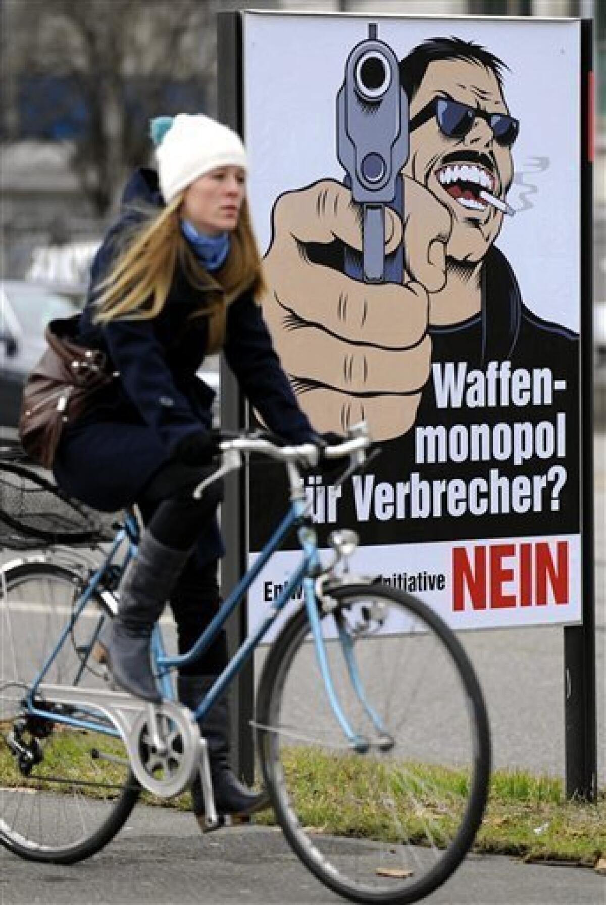 TO GO WITH STORY BY FRANK JORDANS - FILE - In this Jan. 11, 2011 file picture a woman passes a poster reading: 'Weapons Monopoly for Criminals? No' in Zurich, Switzerland. Swiss gun culture meets grassroots democracy Sunday, Feb 13, 2011 in a referendum dividing those who hope to cut the country's high rate of firearms suicides and those who fear tighter rules may kill off village shooting clubs and even cripple Switzerland's legendary citizen militia. (AP Photo/Keystone/Walter Bieri,File )