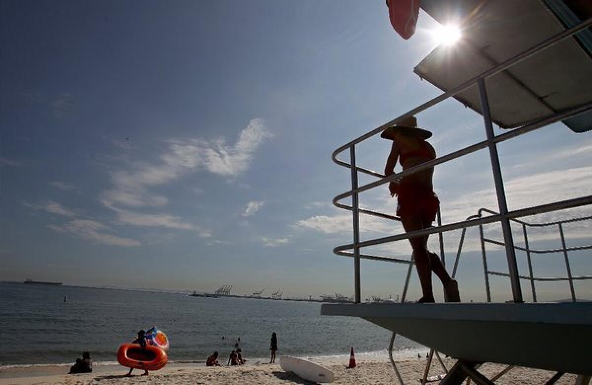 A lifeguard keeps watch over swimmers in Long Beach, where temperatures soared over the Labor Day weekend. The Southland is in the grip of a new heat wave that is expected to last until at least Friday.
