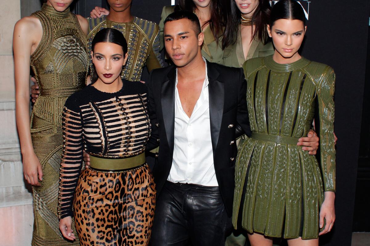 Fashion designer Olivier Rousteing, center, Kim Kardashian, left, and her sister Kendall Jenner pose at a party hosted by Vogue in Paris in July.