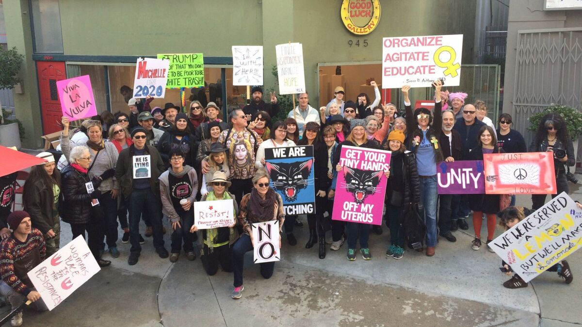 Artists and arts workers gather in front of the Good Luck Gallery in Chinatown before attending the women's march in downtown L.A.