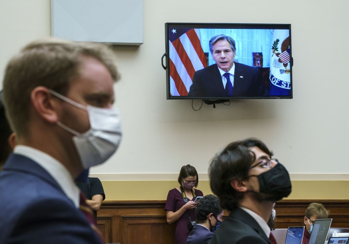 Secretary of State Antony Blinken appears remotely on a TV monitor before the House Foreign Affairs Committee.