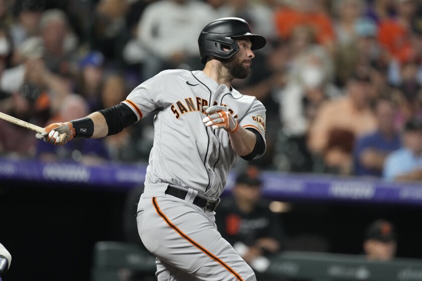 Brandon Belt, de los Gigantes de San Francisco, conecta un sencillo ante los Rockies de Colorado, el sábado 25 de septiembre de 2021 (AP Foto/David Zalubowski)