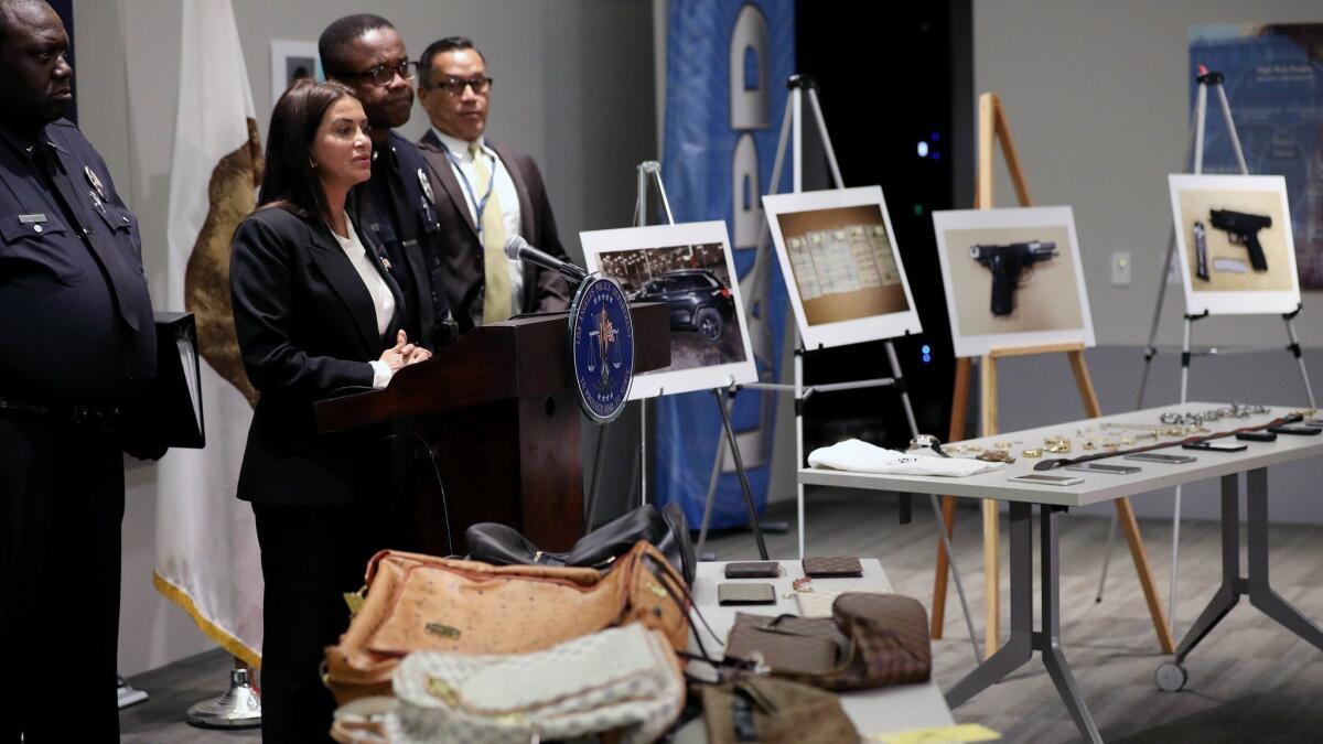 Stolen objects are displayed while Capt. Lillian Carranza, second from left, commanding officer of the Los Angeles Police Department's Commercial Crimes Division, shares details about arrests made in connection with recent burglaries at the homes of celebrities.