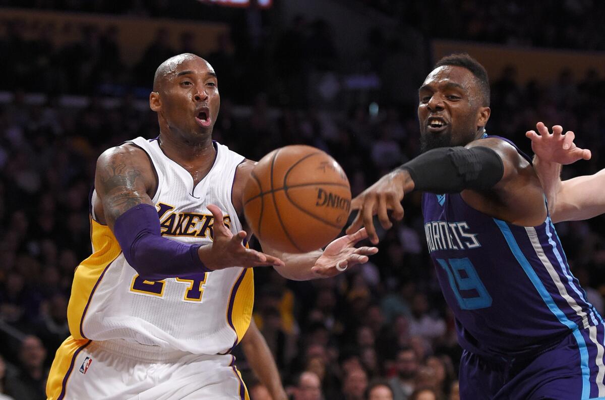 Lakers forward Kobe Bryant, left, and Hornets forward P.J. Hairston fight for a loose ball during the first half.