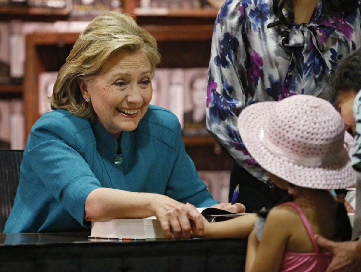 Hillary Rodham Clinton greets a young girl at a book signing in Denver on Monday.
