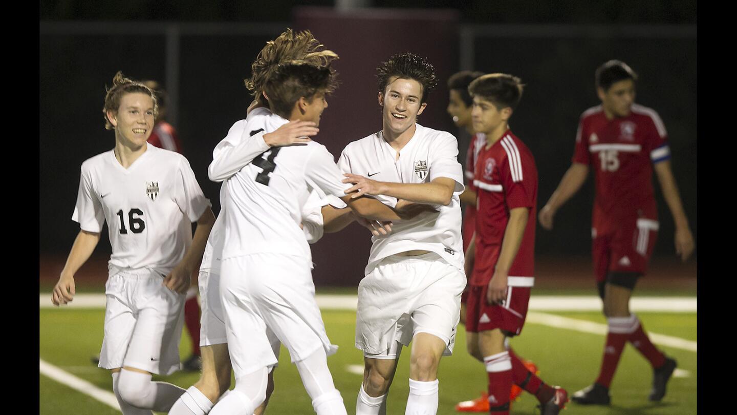Laguna's Jet Rocha, 14, and Carson Cushing, right, 8, celebrate with teammates after a give-and-go goal against Estancia in boys varsity soccer game at Laguna Beach High on Wednesday.