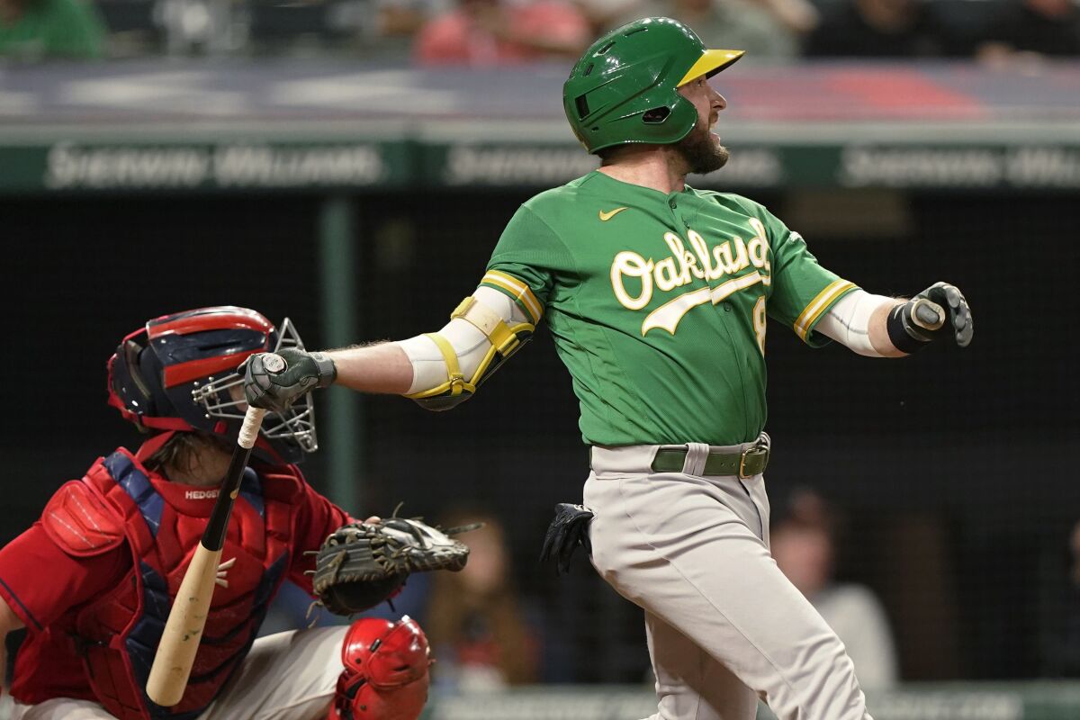 Oakland Athletics' Jed Lowrie watches his RBI double during the 10th inning of the team's baseball game against the Cleveland Indians, Tuesday, Aug. 10, 2021, in Cleveland. Oakland won 4-3 in 10 innings. (AP Photo/Tony Dejak)