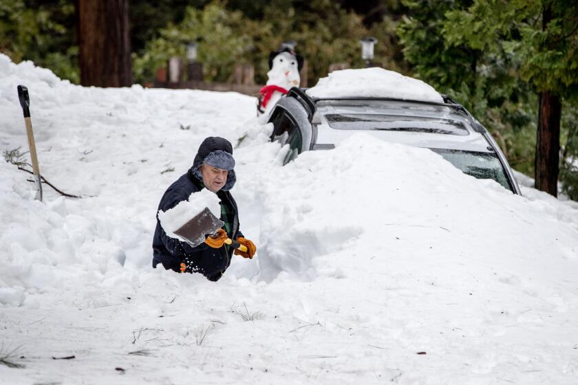 CRESTLINE, CA - MARCH 6, 2023: Standing waist-deep in snow, Mark Thomas shovels a path from his house to the street on March 6, 2023 in Crestline, California. Recent storms dropped more than 100 inches of snow in the San Bernardino Mountains stranding many residents (Gina Ferazzi / Los Angeles Times)