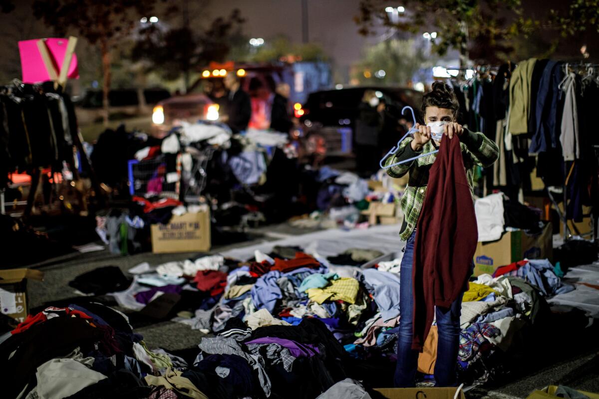 Jessica Sijan sorts out clothes for evacuees gathered at a Walmart parking lot in Chico.