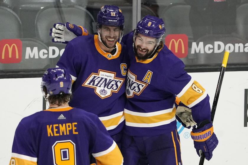 Los Angeles Kings center Anze Kopitar, center, celebrates his empty net goal with defenseman Drew Doughty, right, and right wing Adrian Kempe during the third period of an NHL hockey game against the St. Louis Blues Wednesday, March 17, 2021, in Los Angeles. The Kings won 4-1. (AP Photo/Mark J. Terrill)