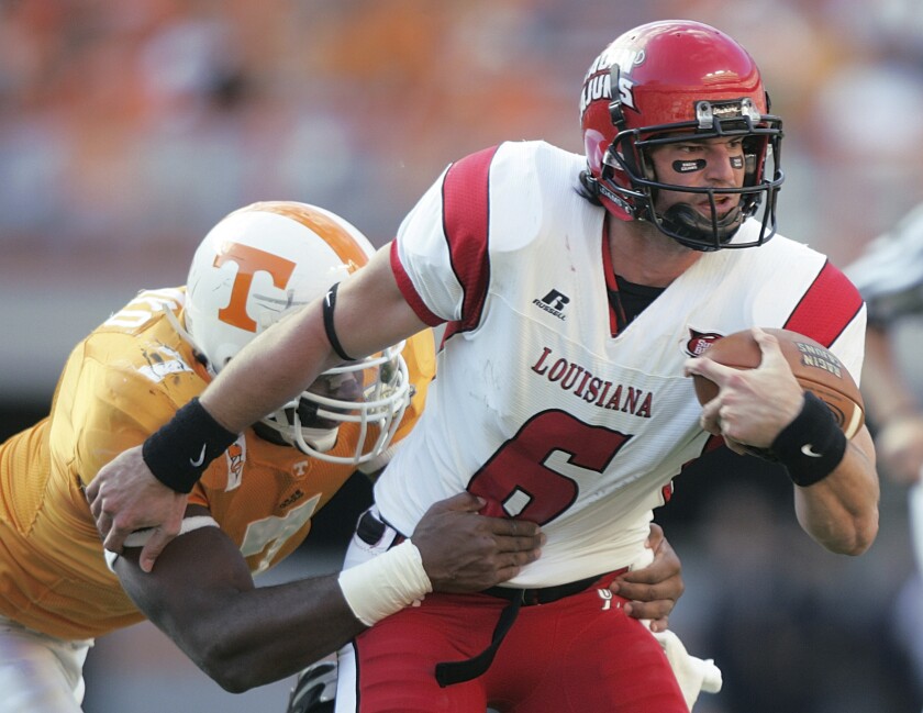 FILE - Louisiana Lafayette quarterback Michael Desormeaux, right, is tackled by Tennessee's Jerod Mayo, left, during an NCAA college football game Saturday, Nov. 3, 2007, in Knoxville, Tenn. No. 16 Louisiana-Lafayette promoted co-offensive coordinator and former Ragin' Cajuns quarterback Michael Desormeaux to head coach on Sunday, Dec. 5, 2021. (AP Photo/Wade Payne, File)