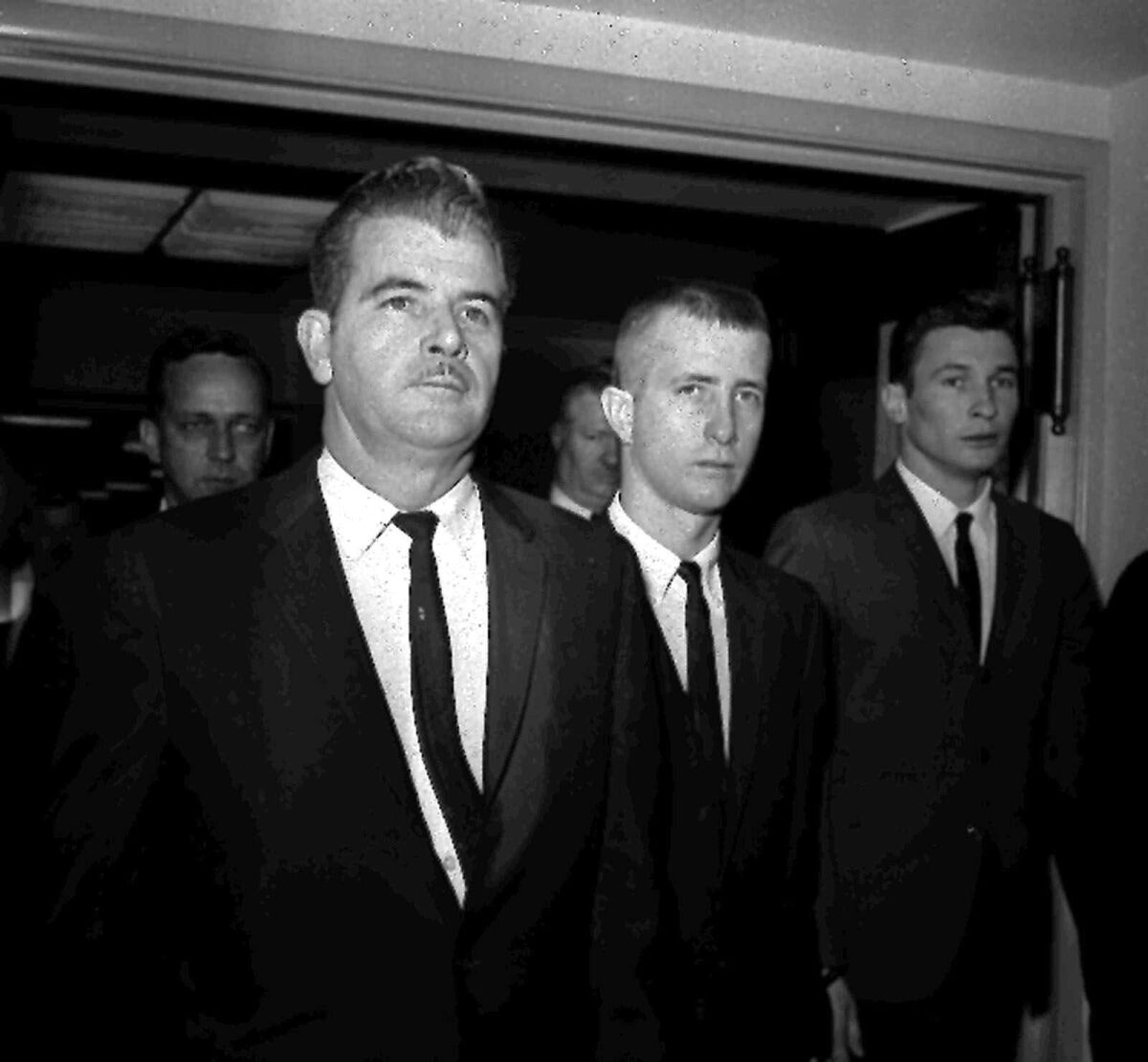 A black-and-white photo of three men in suits and ties