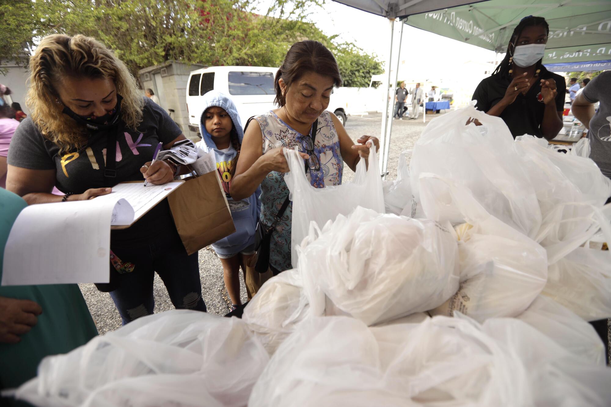 People receive bags of food 