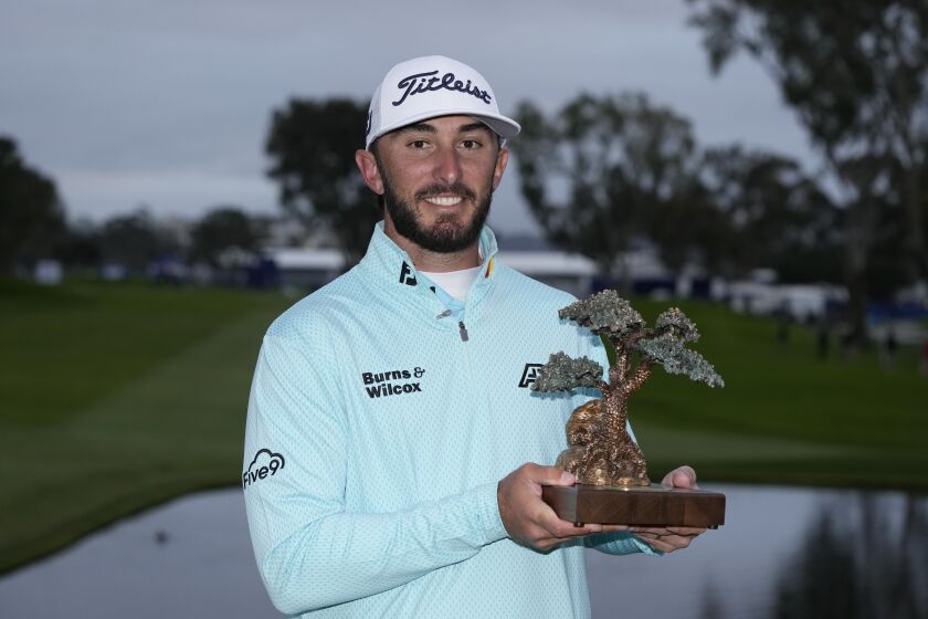 Max Homa holds the trophy after winning the Farmers Insurance Open golf tournament, Saturday, Jan. 28, 2023, in San Diego. (AP Photo/Gregory Bull)