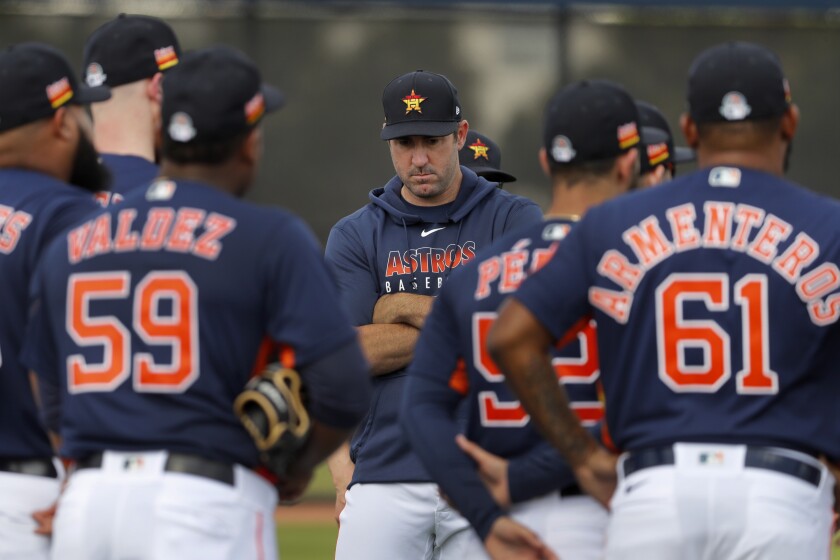 Houston Astros pitcher Justin Verlander crosses his arms as he stands with his teammates at the start of their first spring training baseball workout of the season Thursday, Feb. 13, 2020, in West Palm Beach, Fla. (AP Photo/Jeff Roberson)