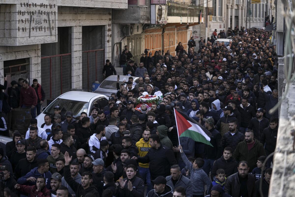 Street packed with mourners in the West Bank refugee camp of Qalandia