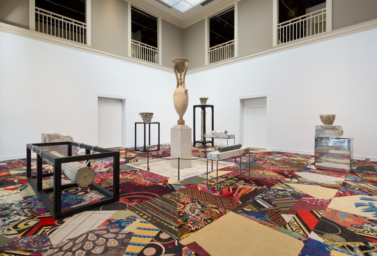 A horizontal image shows a quilt of garish casino carpets topped by architectural fragments from ancient ruins.