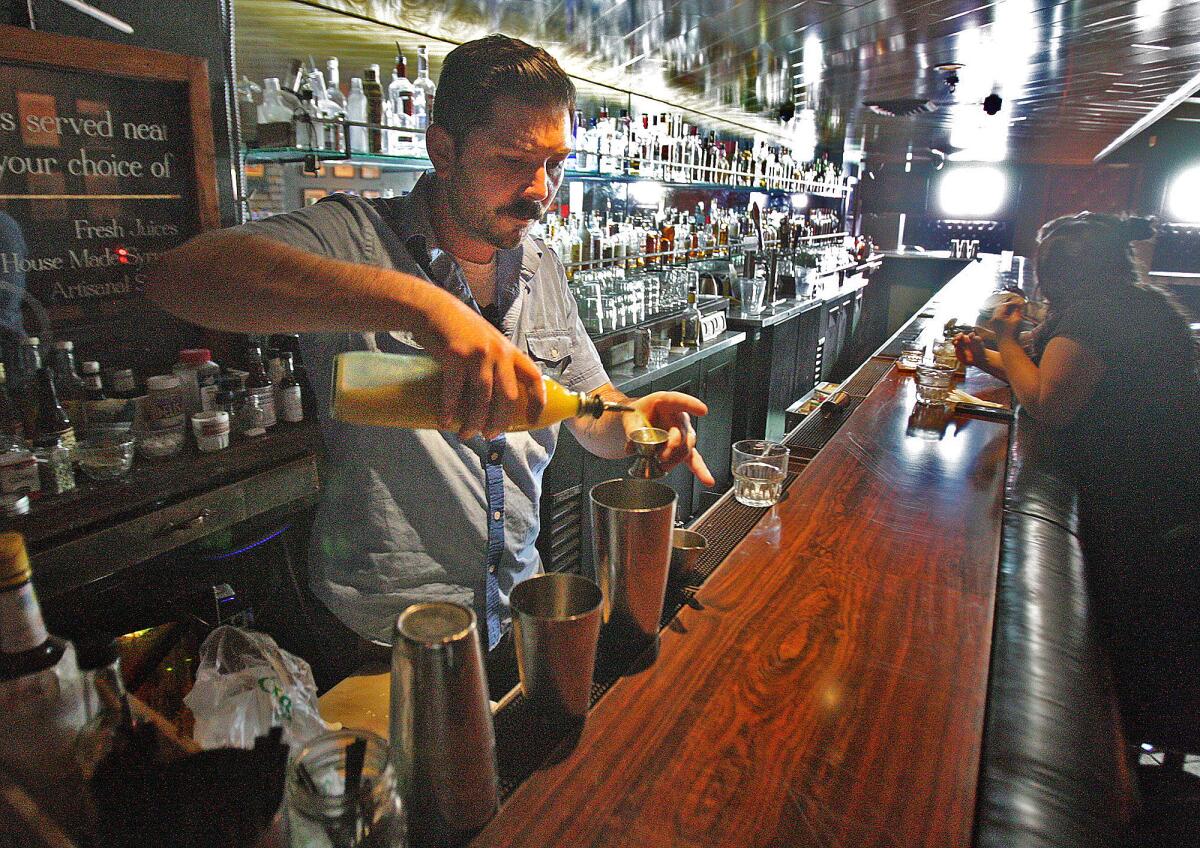 Co-owner of the Neat Bar Xanthus Be Dell pours a drink for a customer at the Neat Bar in Glendale on Friday, August 29, 2014. The bar will be the site of the next meetup hosted by the Glendale Historical Society as part of their new yearlong series kicked off this week, called "Raising the Bar" in which they meet with anyone interested in history and preservation at local and longtime bar establishments in Glendale.