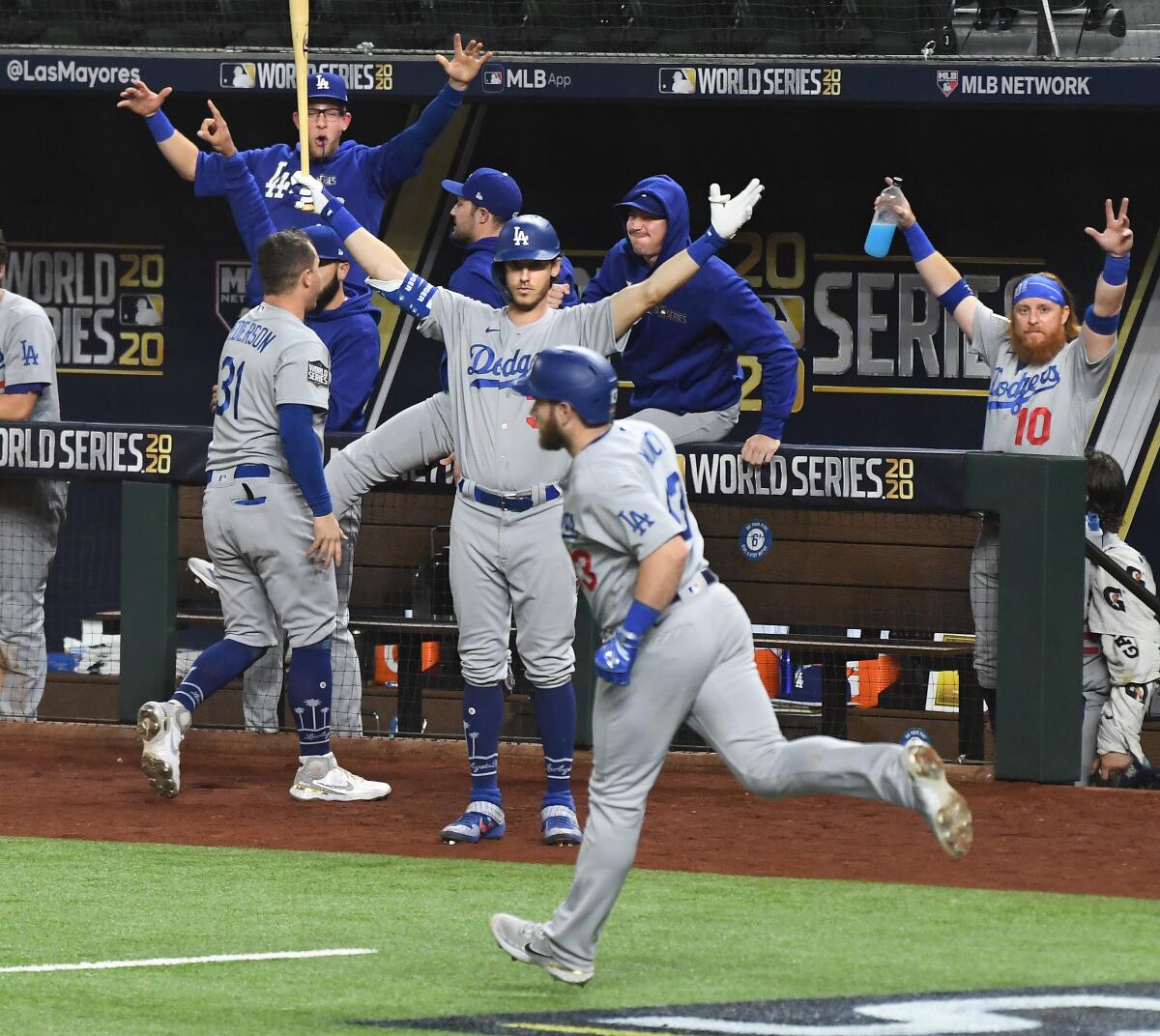 Dodgers first baseman Max Muncy rounds the bases as the dugout celebrates his solo home run.