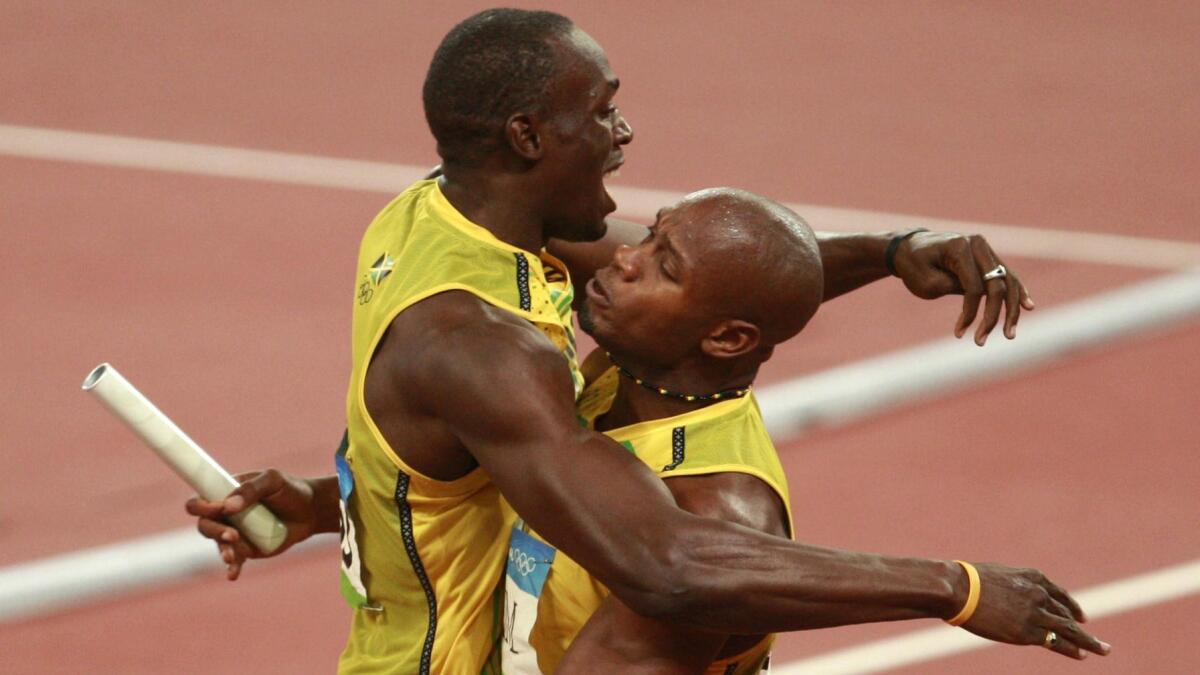 Jamaica's Usain Bolt, left, and Asafa Powell celebrate winning the gold in the men's 400-meter relay at the 2008 Beijing Olympics.