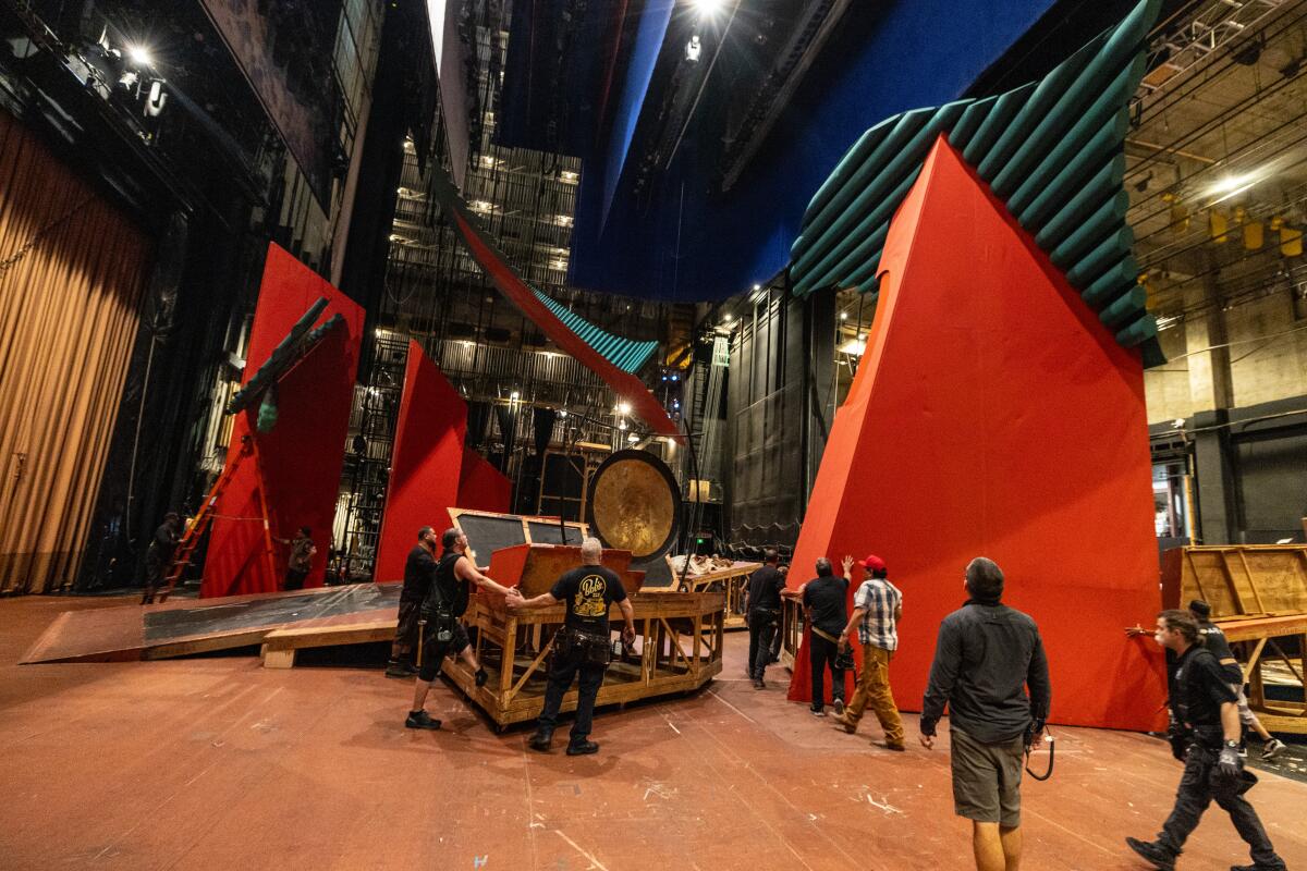 Workers move pieces of the "Turandot" set during tech rehearsal this week.