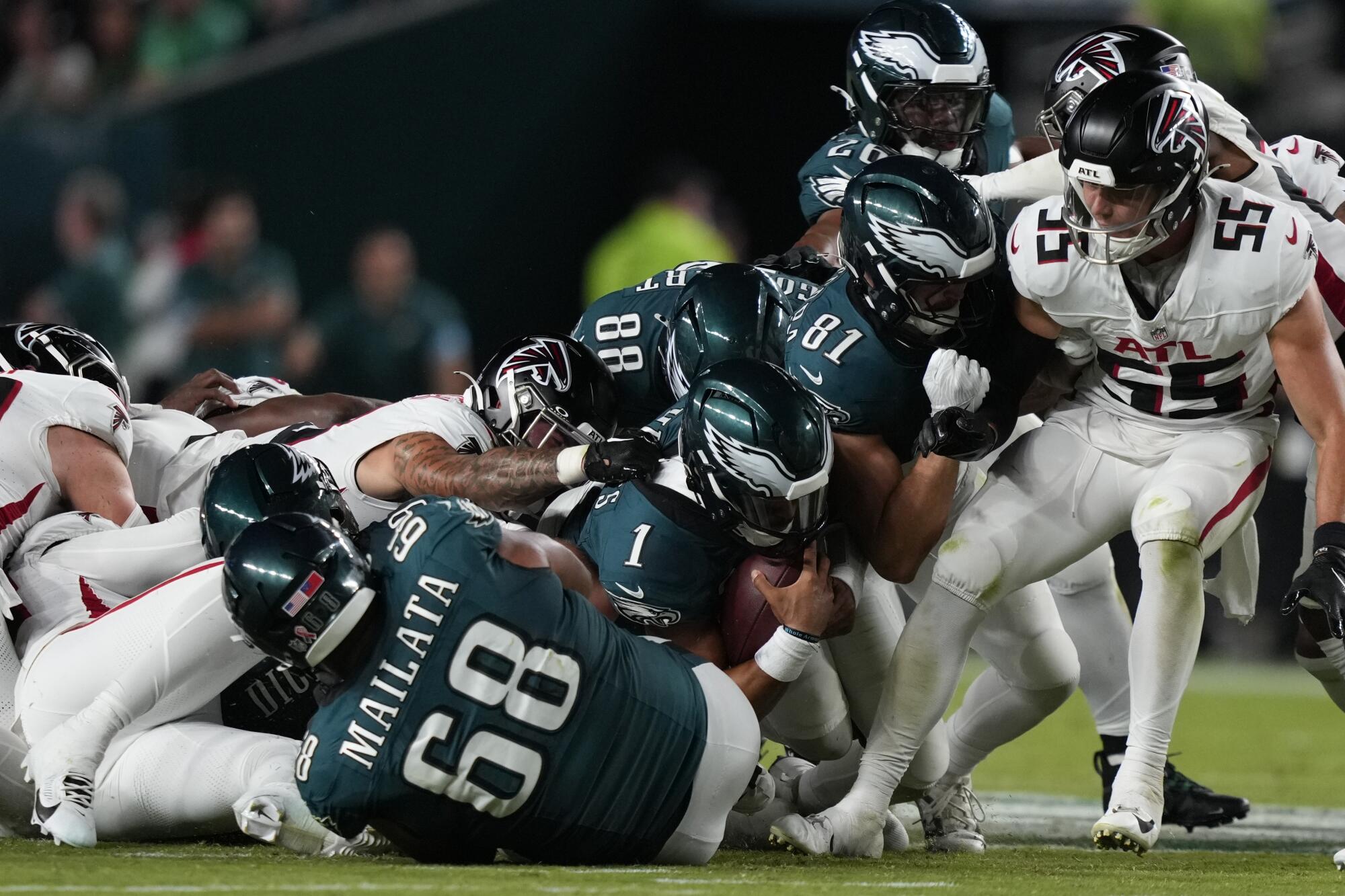 Philadelphia Eagles quarterback Jalen Hurts tries to pick up a first down on a shove play against the Atlanta Falcons.
