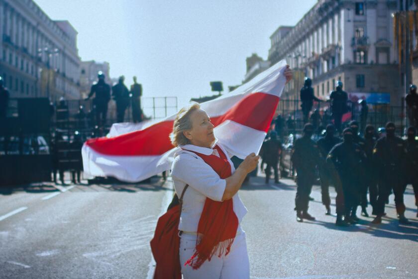 A woman unfurls a Belarusian flag in the 2021 documentary “Courage”
