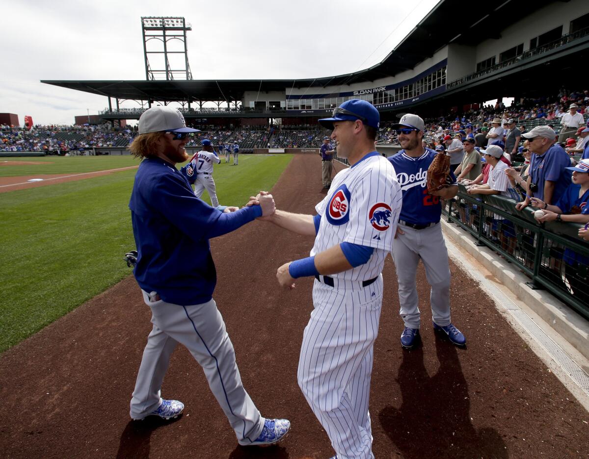 Dodgers third baseman Justin Turner greets Chicago Cubs third baseman Chris Valaika before a spring training game Wednesday in Mesa, Ariz.