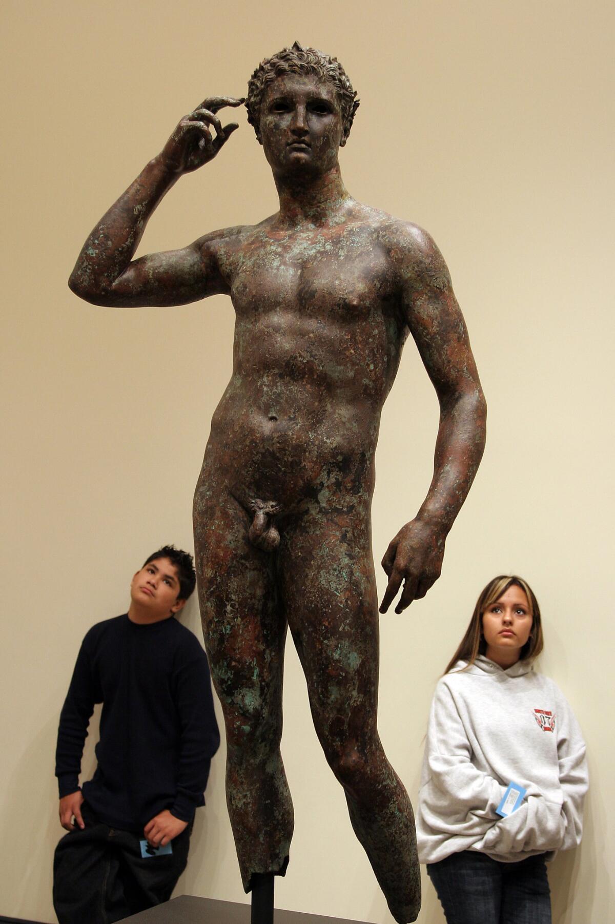 Visitors look at the "Victorious Youth" bronze at the Getty Villa in Pacific Palisades.