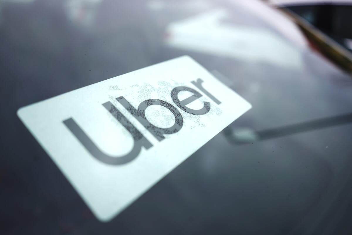 An Uber sign is displayed inside a car.