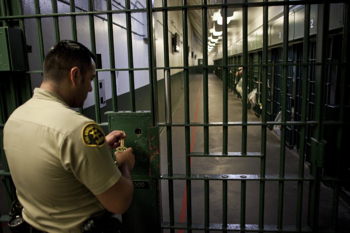 A Los Angeles County sheriff's deputy prepares to unlock a security door to a cell block on the 3000 floor of Men's Central Jail.