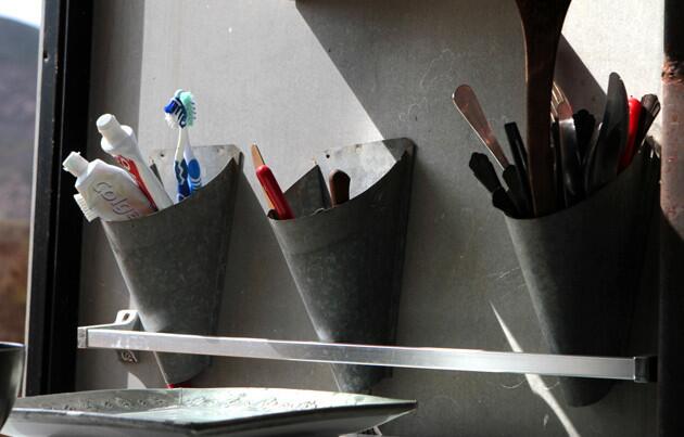 Galvanized sheet metal formed into utensil holders by the kitchen sink.