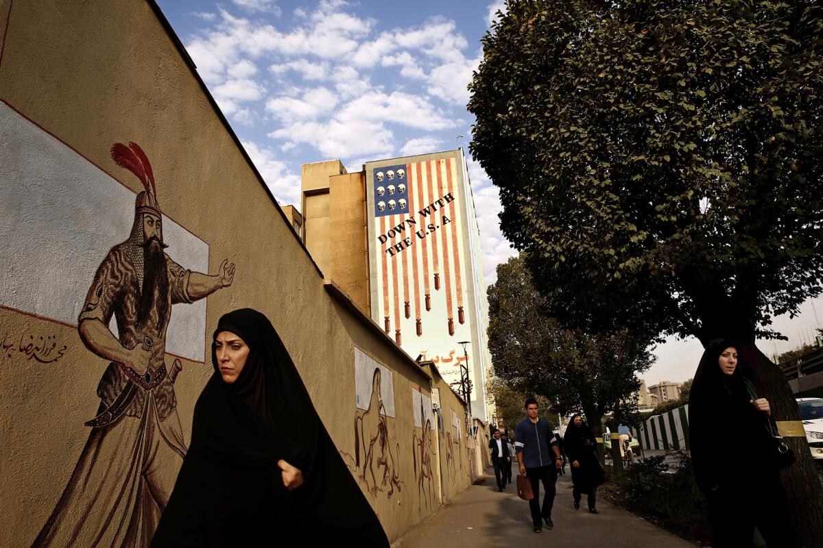A mural of a stylized American flag with the words "Down With the U.S.A." looms over a boulevard in central Tehran.